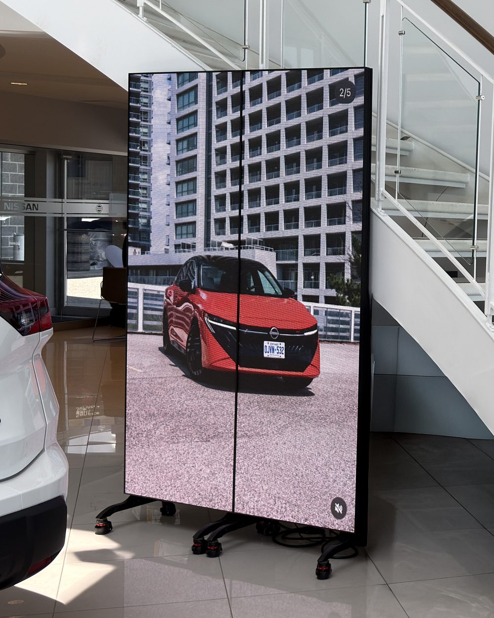 Deux affiches DEL intérieures sur pieds à roulettes dans la salle d’exposition d’un concessionnaire Nissan